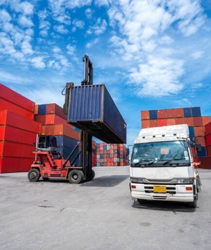 Forklift loading a shipping container onto a truck